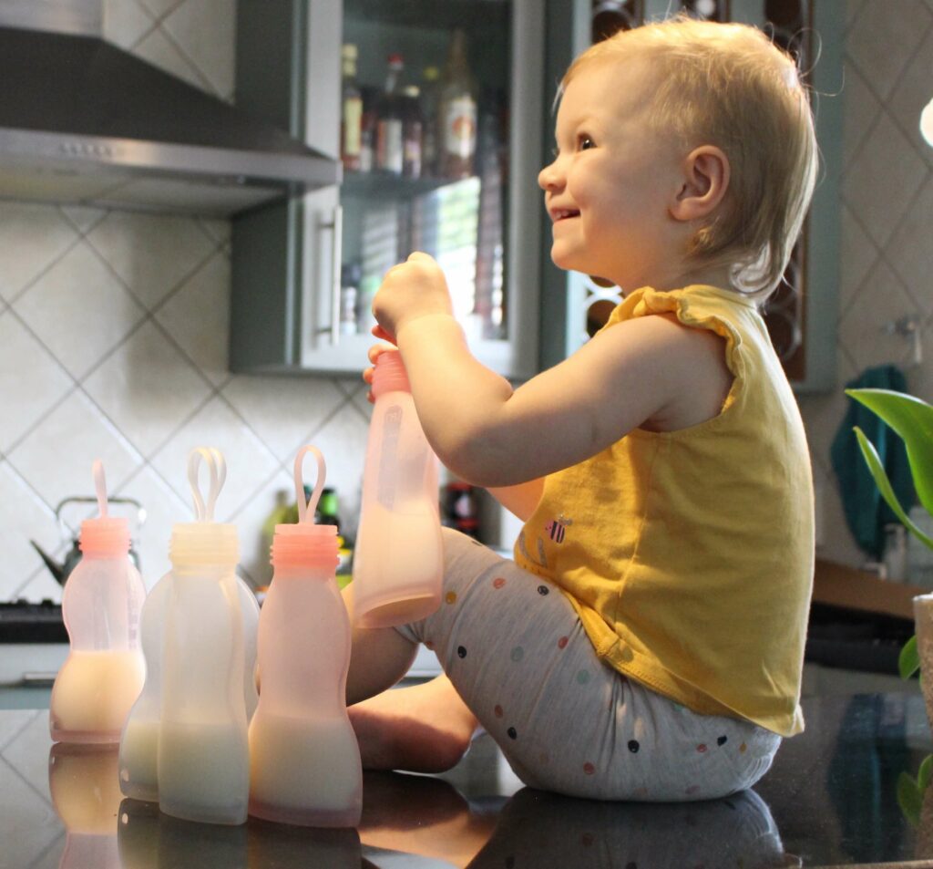 Baby sitting with reusable breastmilk storage bags